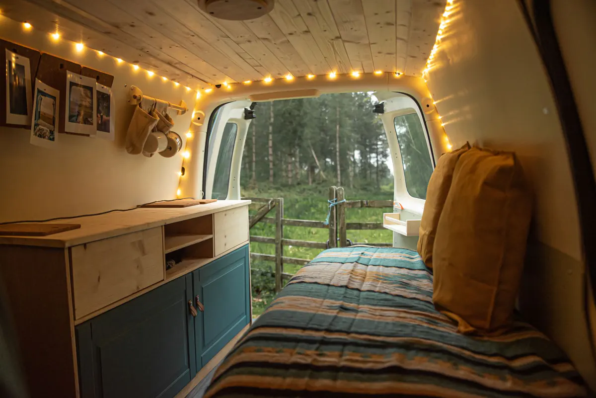 Warm camper interior opening toward a forest